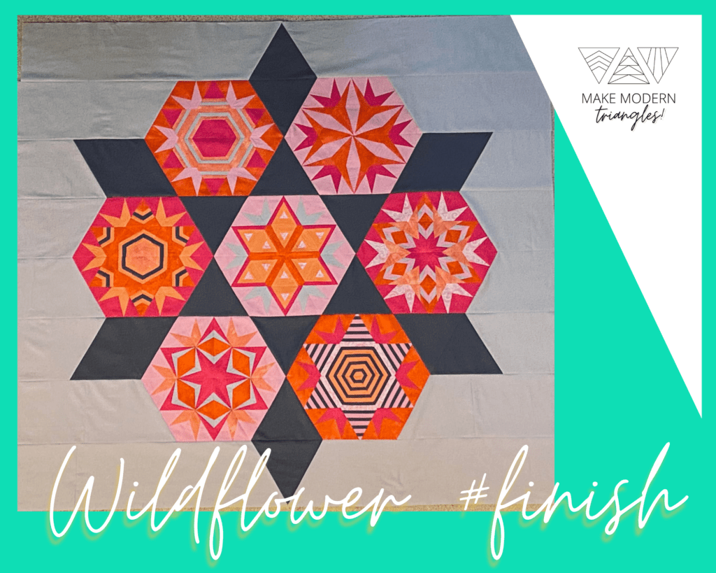 Make Modern Triangles featured member photo of a Wildflower BOM quilt finish.