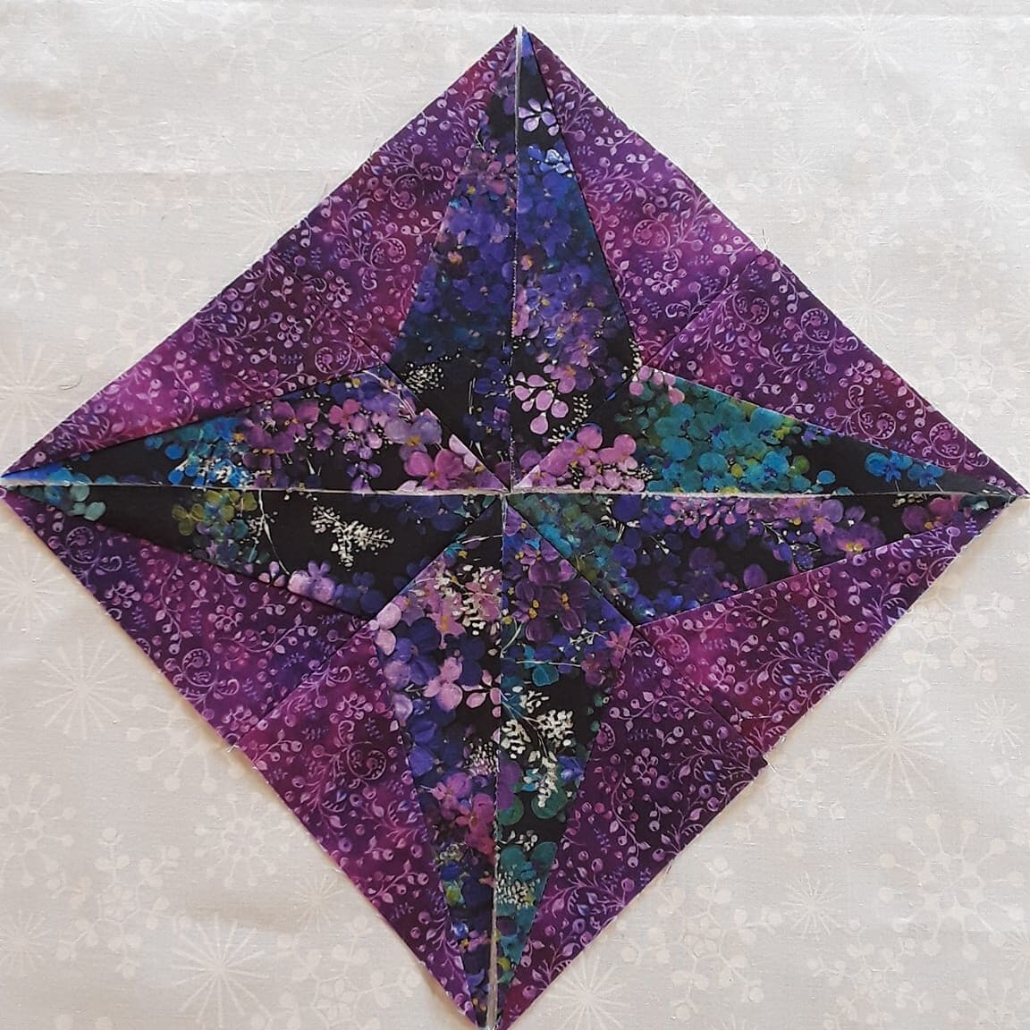 Sparkler BOM Month 2 block made with purple, teal, green and pink fabrics.