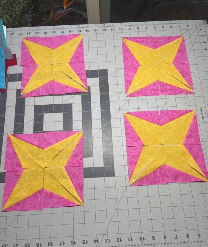 Sparkler BOM month 2 blocks made by a member with yellow and bright pink fabrics.