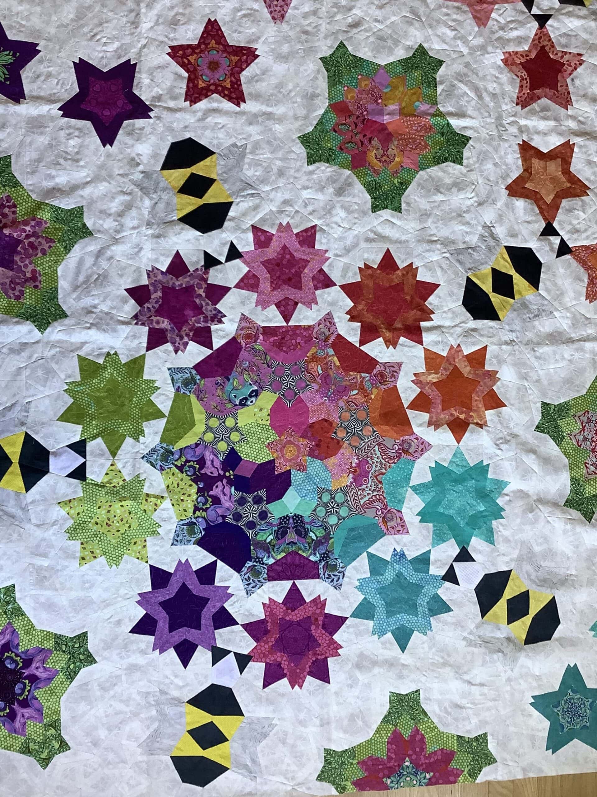 Lots of small triangles make a modern triangle quilt in this Pollinator quilt design made by Debbie U.