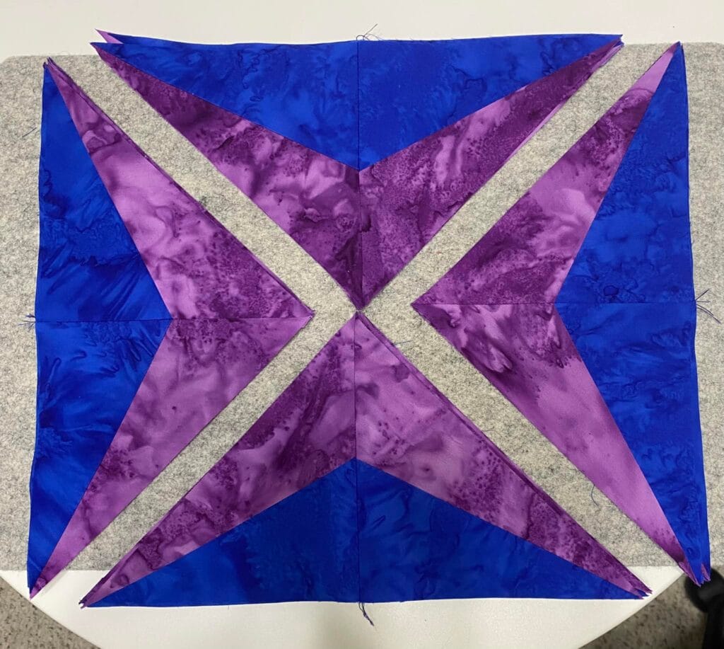 Sparkler BOM Month 2 block in purple and bright royal blue colors.