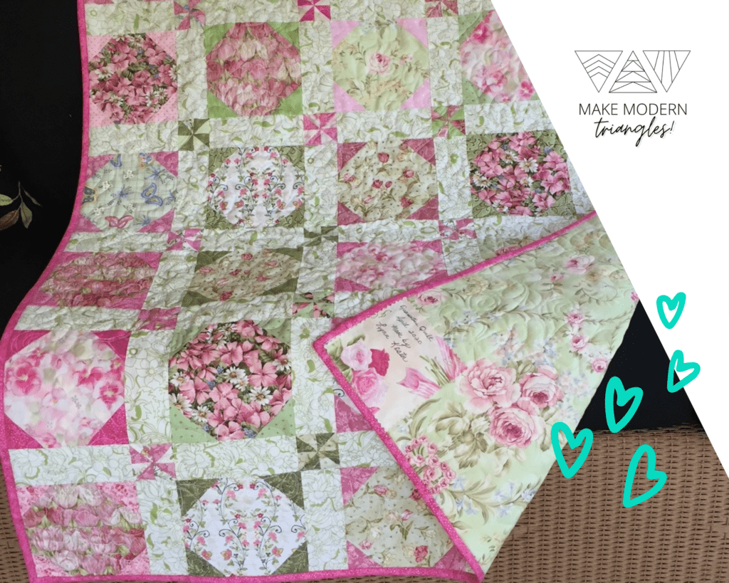 Floral fabrics in pinks and greens are pieced in a traditional style.