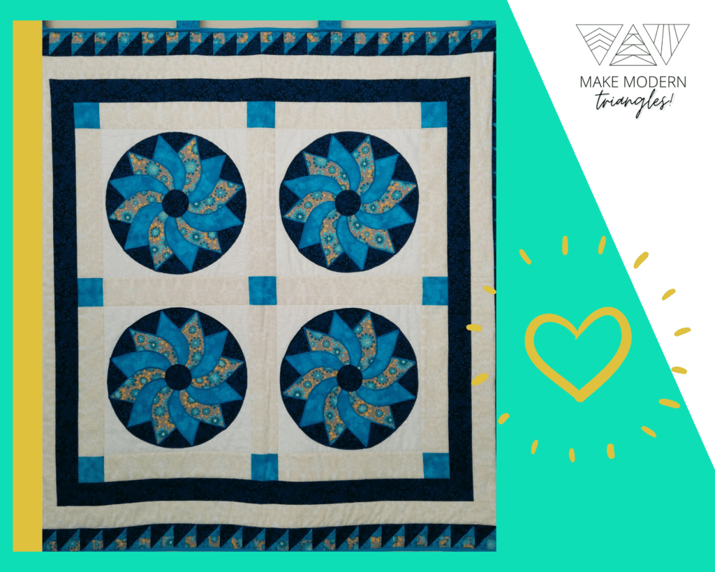 Featured spotlight Make Modern Triangles member Shirley M. quilted wall hanging applique quilt in black, blues and tan colors.