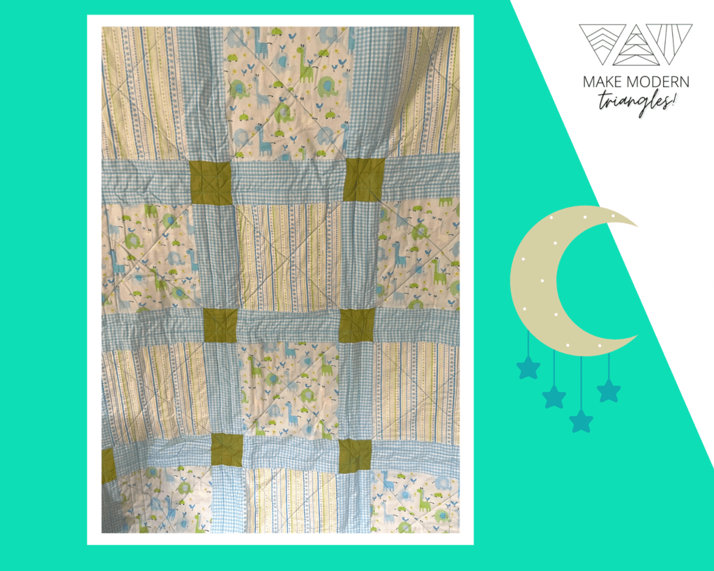 A baby quilt made with light blue, teal and green print fabrics. Made by Marilyn W., the member spotlight for Make Modern Triangles,