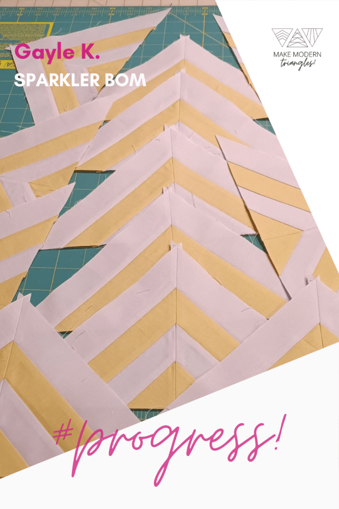 Photo of Make Modern Triangles member's Sparkler BOM block made in light orange and light pink fabrics. 