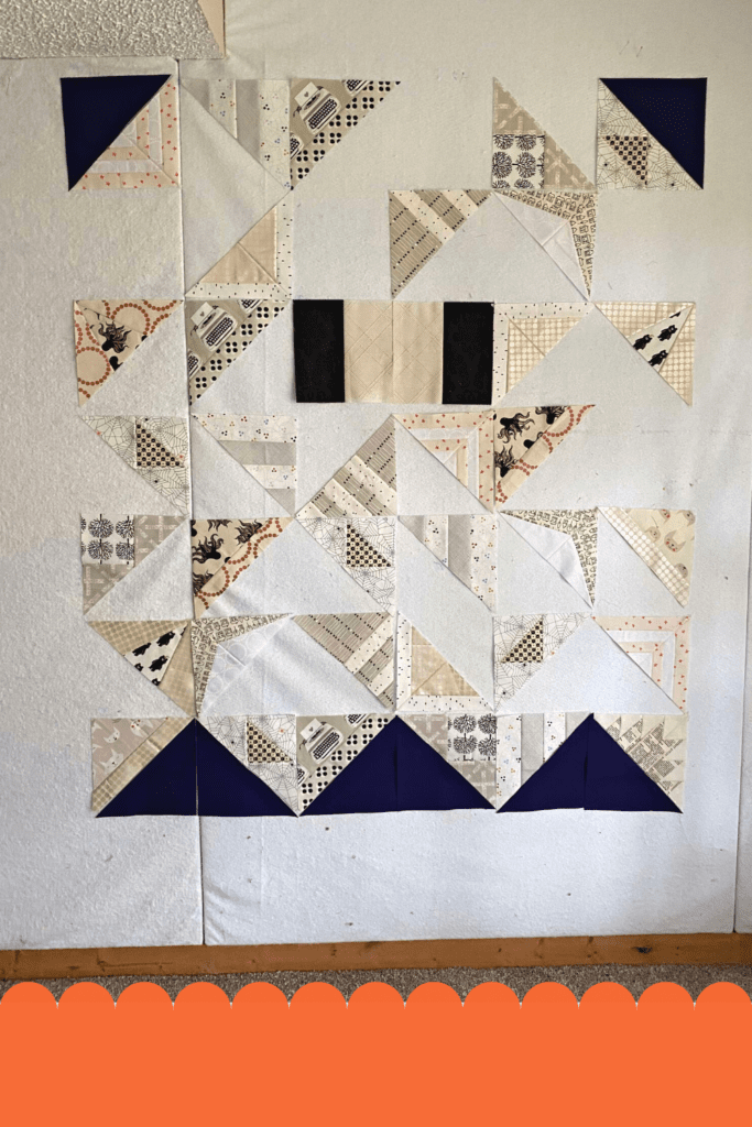 Adding all of the sewn modern triangles to design wall.