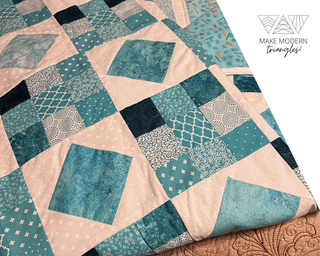 Teal and cream fabrics in nine-patch block style quilt made by Deann W.