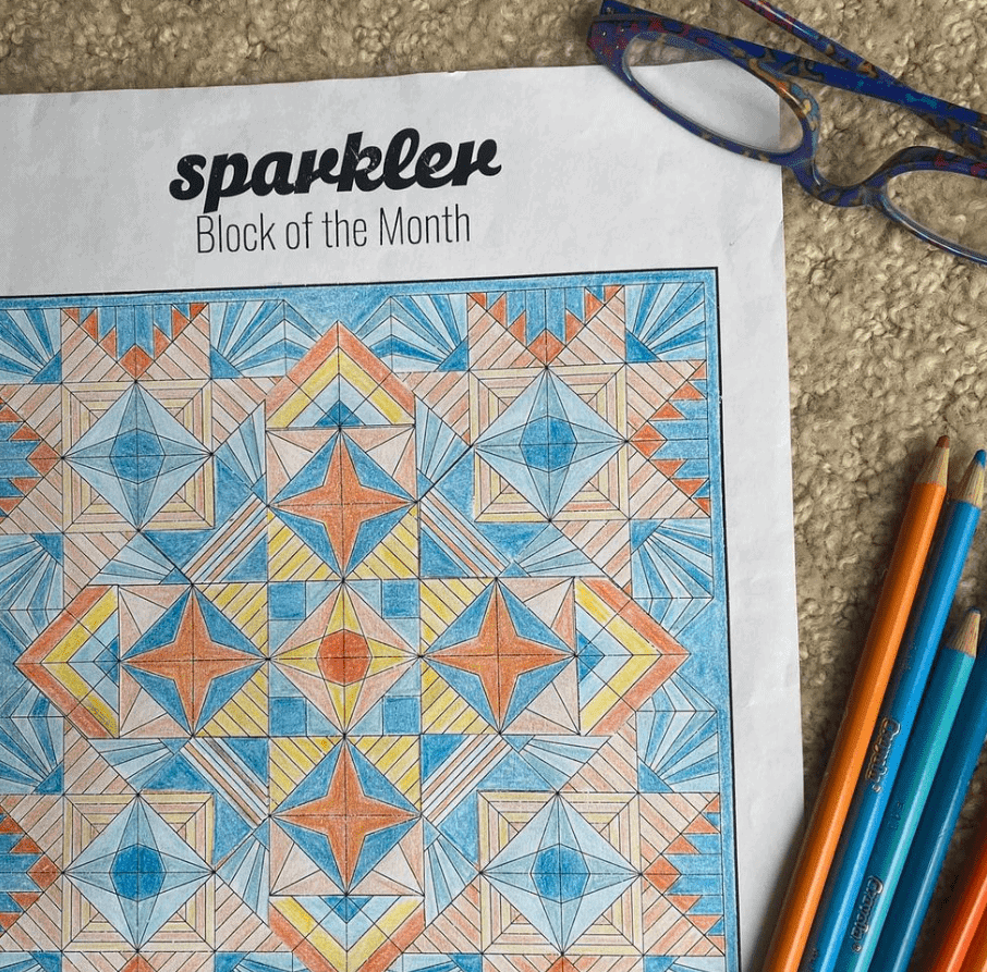 Coloring sheet for Sparkler quilt design completed using colored pencils in bludes, orange and yellow.