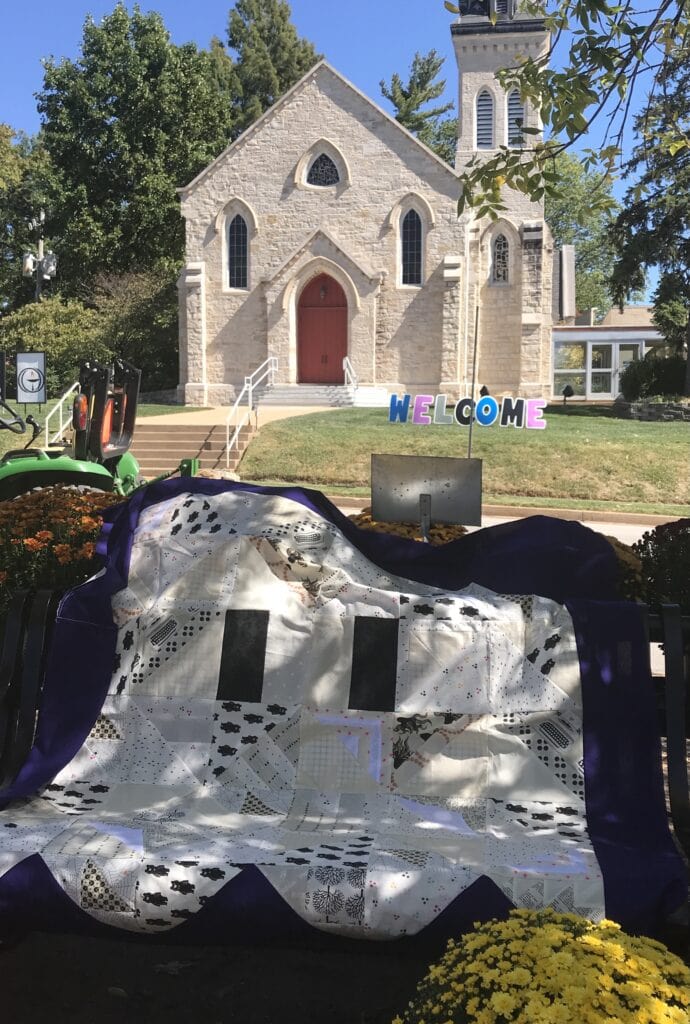 Photo of quilt with a ghost motif made from triangle blocks.