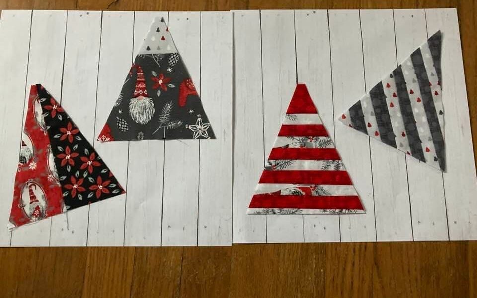 Karen S. used red, black and gray print fabrics to make triangle blocks for the Merry Modern Triangles Quilt along.