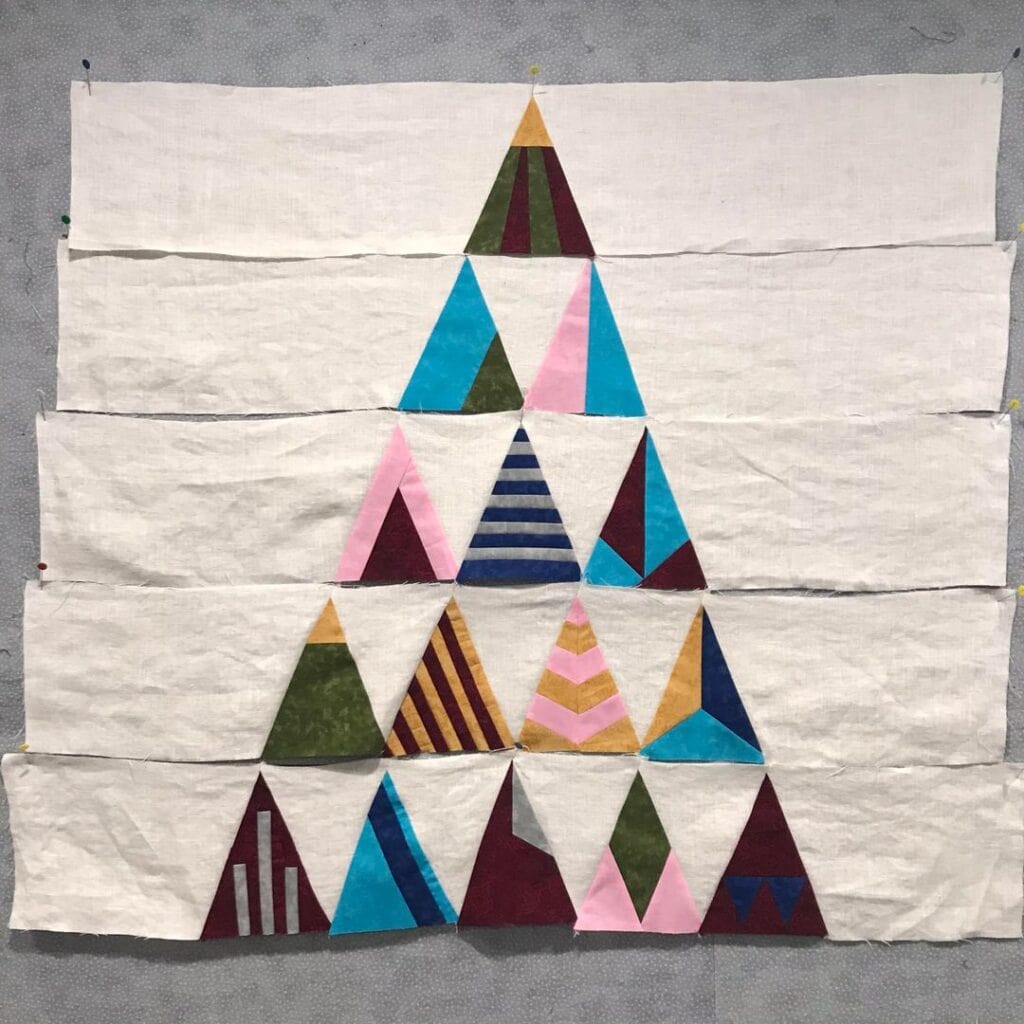 Member Lillian N. pieced her rows of triangles together with the background pieces.