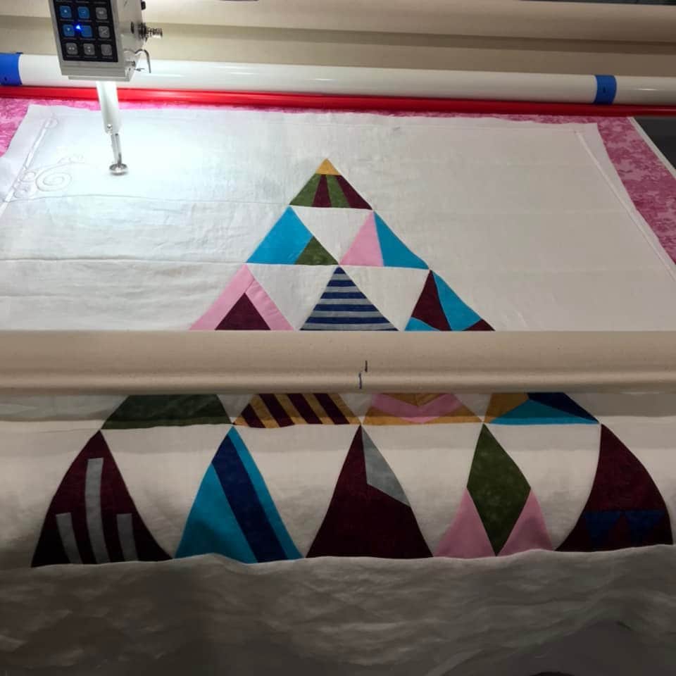 Lillian N.'s quilt is loaded onto the longarm machine ready to quilt.