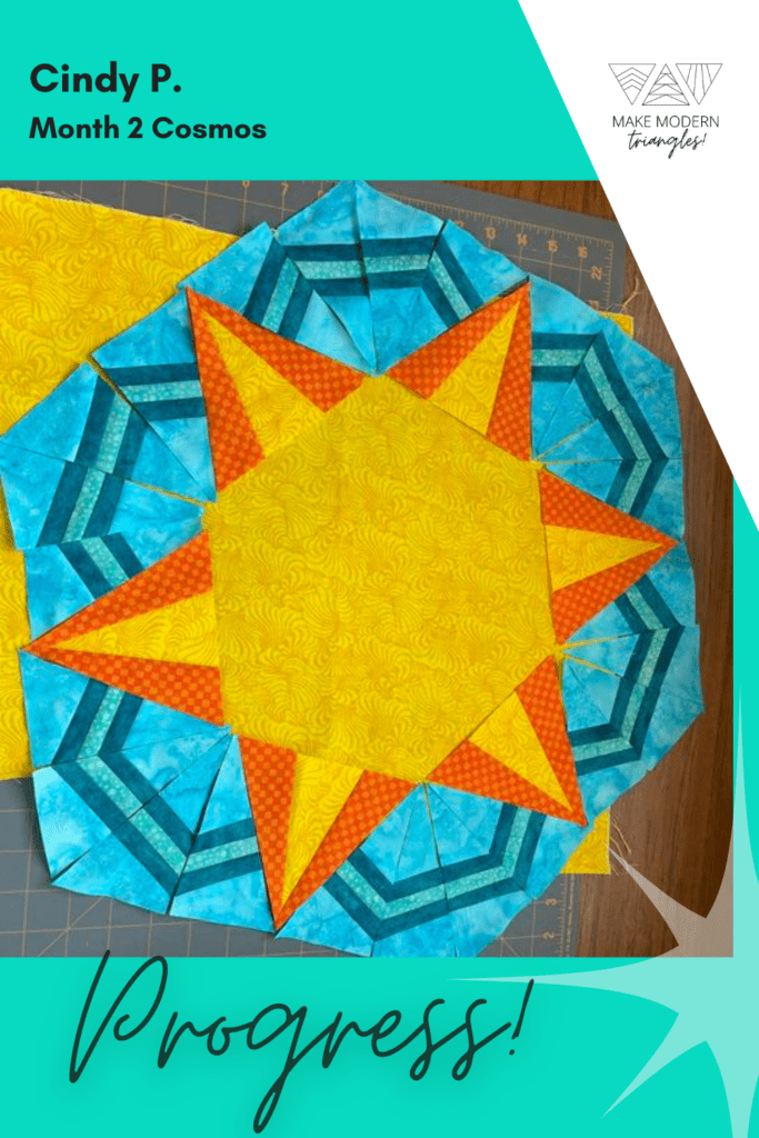 Cosmos Month 2 member make in orange, yellow, blue and green fabrics.