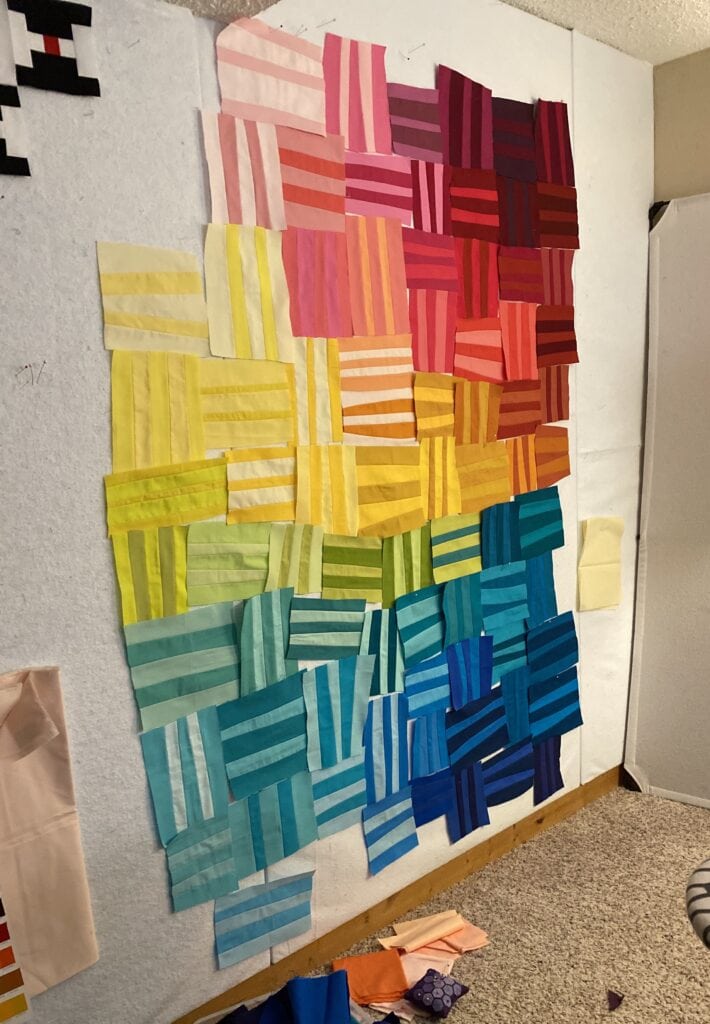 Photo shows a rainbow quilt in progress by Bryan House Quilts