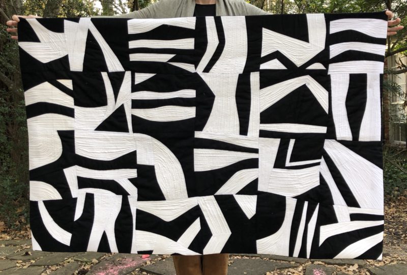 Black and White Improv Curves quilt bound with an invisible facing