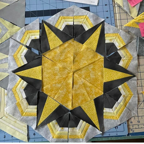 Cosmos quilt center block forms a hexagon from triangles