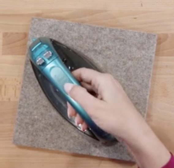 Ironing fabric on a wool pressing mat