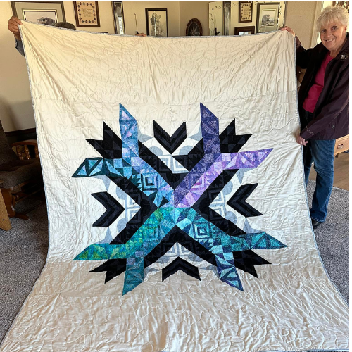 Aurora BOM quilt finish by Make modern triangles member in cool colors.