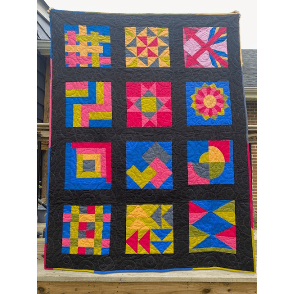 Bright, bold sampler quilt in a modern style block layout