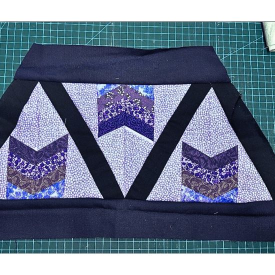 Triangle BOM blocks close up in violet and blue prints.