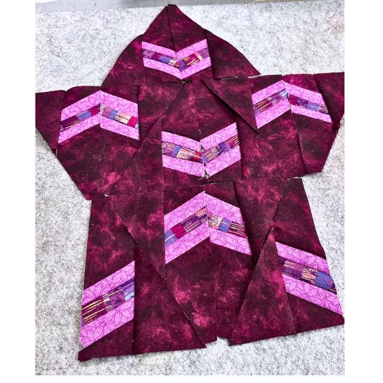 Triangle BOM blocks in magenta and bright pink fabrics. 