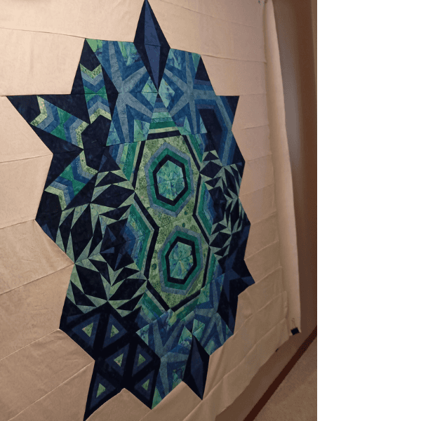 Freezer paper pieced Echo quilt in blues greens and teals.