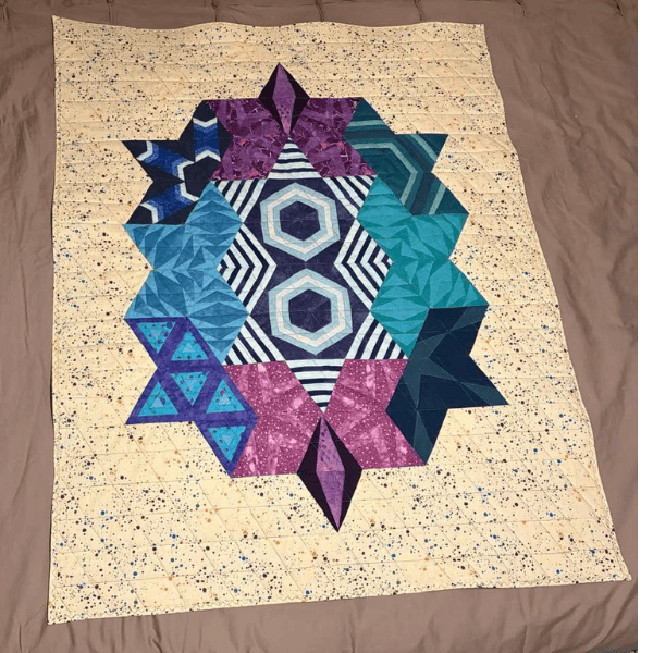Making progress with muscle memory makes it possible to finish a freezer paper pieced quilt in jewel tones.